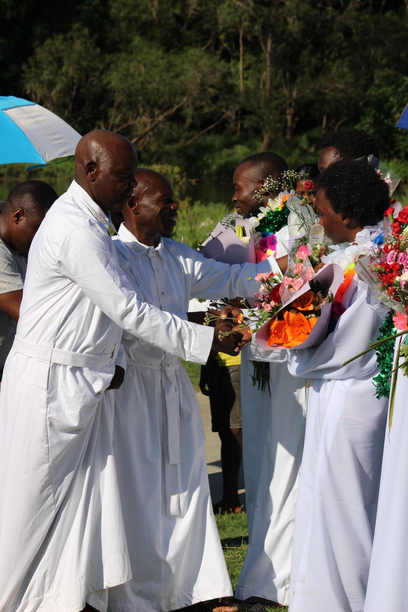 Pastors congratulating baptised members