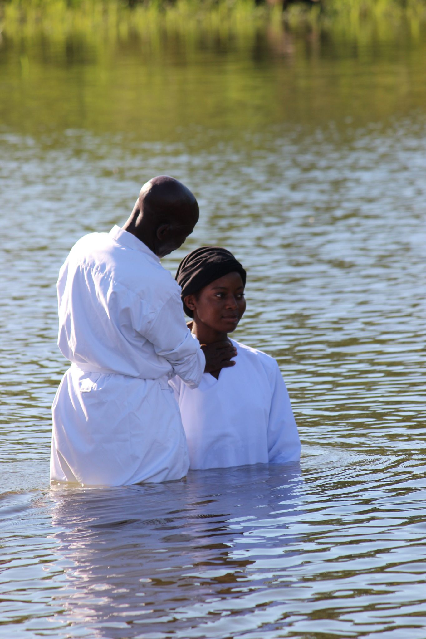 Pastors congratulating baptised members